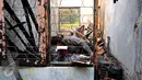 Seorang petugas kepolisian saat memeriksa salah satu ruangan Kantor Komisi Nasional Perlindungan Anak pasca terbakar, Jakarta, Senin (29/6/2015). Kantor Komnas PA terbakar pada Sabtu, 28 Juni 2015 sekitar pukul 21.00 WIB. (Liputan6.com/Yoppy Renato)
