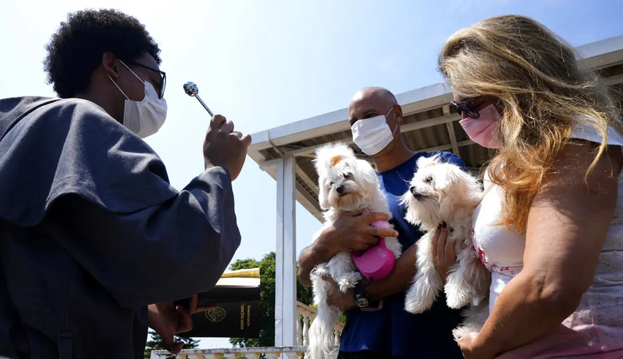 Seorang Fransiskan memberkati anjing peliharaan dalam misa untuk menghormati Santo Fransiskus dari Assisi pada Hari Raya Santo di Brasilia, Brasil, Senin (4/10/2021). Santo Katolik dianggap sebagai pelindung hewan. (AP Photo/Eraldo Peres)