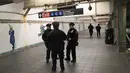 Aparat kepolisian berjaga di lorong stasiun kereta bawah tanah dekat lokasi teror bom pipa di New York City, Senin (11/12). Imigran asal Bangladesh, Akayed Ullah (27), menjadi tersangka pelaku ledakan. (JOHN MOORE / GETTY IMAGES NORTH AMERICA / AFP)