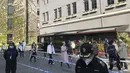Warga mengantre untuk tes massal di area penguncian di distrik Jingan di Shanghai barat (4/4/2022). Pengiriman petugas kesehetan untuk membasmi wabah COVID-19 yang menyebar dengan cepat di kota terbesar di China. (AP Photo/Chen Si)