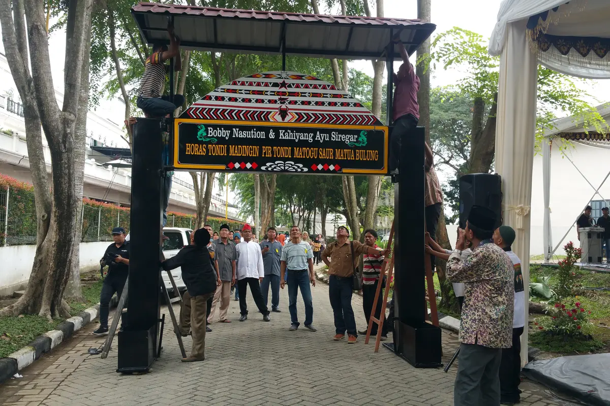Para pekerja dan panitia tampak sibuk merampungkan berbagai dekorasi yang sudah didesain dengan corak adat Sumatera Utara (Liputan6/Nanda Perdana Putra)