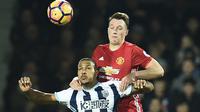Pemain Manchester United, Phil Jones (kanan) berebut bola dengan pemain West Bromwich Albion, Salomon Rondon pada laga Premier League di The Hawthorns stadium, West Bromwich, (17/12/2016). MU menang 2-0. (AFP/Oli Scarff) 