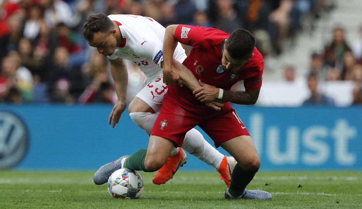 Penyerang Swiss, Xherdan Shaqiri, berebut bola dengan gelandang Portugal, Ruben Neves, pada laga UEFA Nations League di Estadio Do Dragao, Porto, Kamis (6/6) dini hari WIB. Portugal menang 3-1 atas Swiss. (AP/Armando Franca)