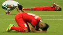 Ekspresi bersyukur Zulfiandi kontras dengan ekspresi kesedihan dua pemain Singapura U-23. (Bola.com/Arief Bagus)