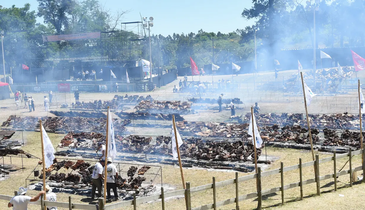 Peserta memanggang daging sapi sebanyak 16.500 kg di Taman Rodo di Minas, Uruguay (10/12). Dengan daging sebanyak 16.500 kg, mereka berusaha memecahkan rekor dunia dengan katagori  "The World's Biggest Barbecue". (AFP Photo/Miguel Rojo)