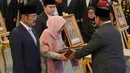 Ia diberikan gelar lantaran perjuangannya menonjol sejak masa kemerdekaan. Tampak dalam foto, Presiden Indonesia Prabowo Subianto (kanan) menyerahkan sertifikat gelar pahlawan nasional kepada putra dan putri mendiang Presiden Suharto, Siti Hardiyanti Rukmana (kedua dari kiri) dan Bambang Trihatmojo, dalam upacara pemberian gelar pahlawan nasional kepada sepuluh tokoh di Istana Negara di Jakarta, Senin 10 November 2025. (AP Photo/Achmad Ibrahim)