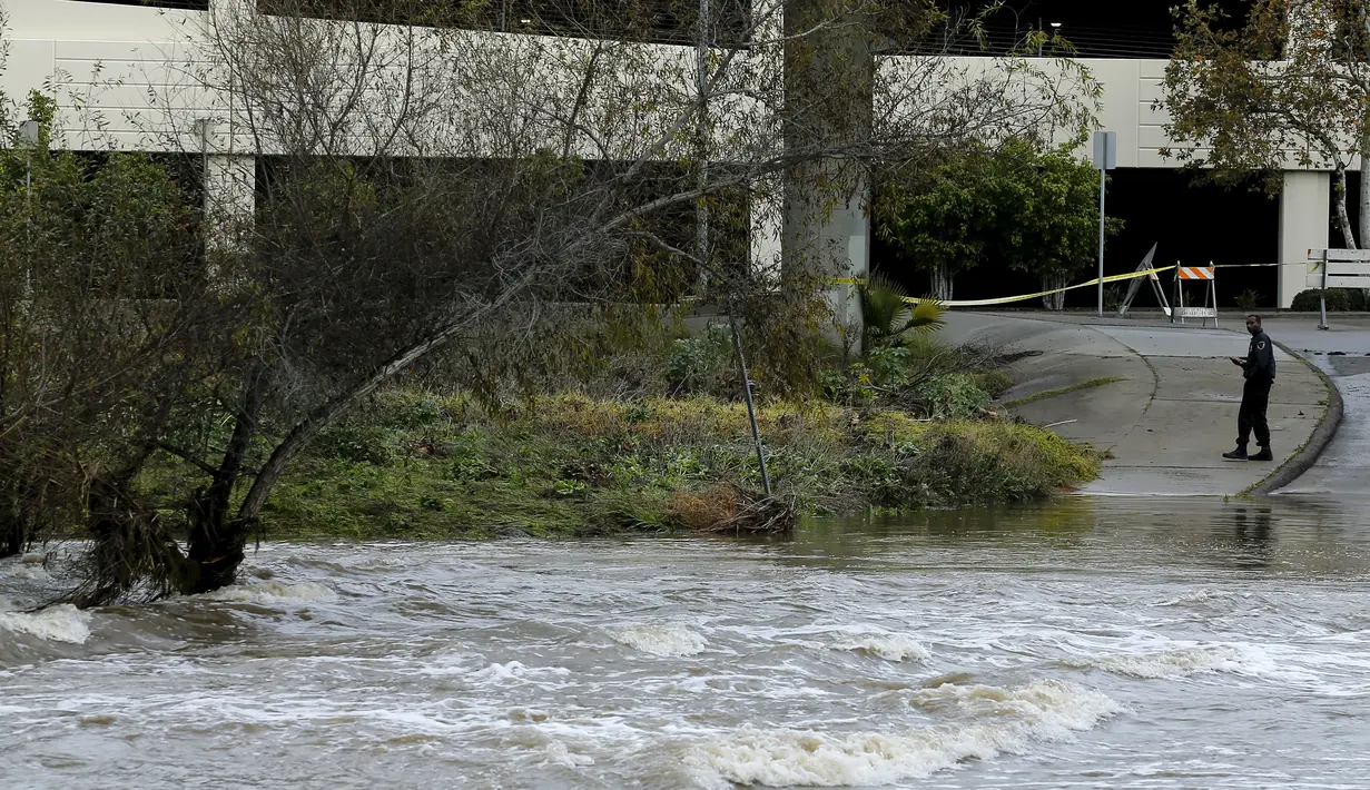 Seorang petugas melihat air yang merendam jalanan sekitar di California, Rabu (6/1/2016). Badai El Nino melanda wilayah selatan California dengan membawa hujan deras ke kawasan yang sempat dilanda kekeringan. (REUTERS/Mike Blake)