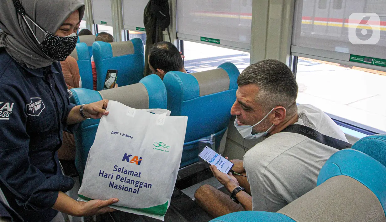 Petugas memberikan bingkisan kepada penumpang KA Taksaka di Stasiun Gambir, Jakarta, Sabtu (4/8/2021). Dalam rangka memperingati hari pelanggan nasional, PT KAI Daop 1 Jakarta membagikan ratusan bingkisan kepada penumpang kereta api. (Liputan6.com/Faizal Fanani)
