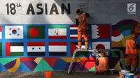 Petugas PPSU Srengseng Sawah menggambar mural bertema Asian Games 2018 di kolong flyover Universitas Indonesia, Depok, Jawa Barat, Jumat (27/7). Perhelatan Asian Games 2018 akan berlangsung di Jakarta dan Palembang. (Liputan6.com/Immanuel Antonius)