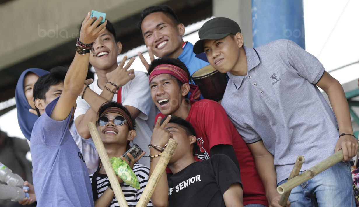 Suporter Universitas Negeri Makassar (UNM) melakukan swafoto saat menonton laga Torabika Campus Cup 2017 di Stadion UNM, Makassar, Kamis, (19/10/2017). UNM berhasil menjadi juara ke tiga pada ajang tersebut. (Bola.com/M Iqbal Ichsan)