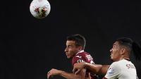 Pemain depan Torino, Alejandro Berenguer berebut bola dengan bek AS Roma, Chris Smalling pada pekan ke-37 Liga Italia di stadion Grande Torino di Turin, Rabu (29/7/2020). AS Roma berhasil mengalahkan tuan rumah Torino 3-2 meski sempat tertinggal lebih dulu. (Fabio Ferrari/LaPresse via AP)