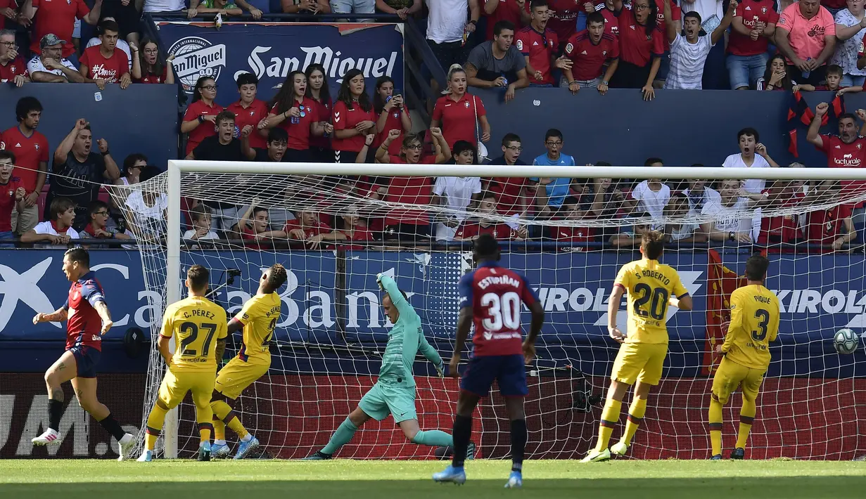 Kiper Barcelona, Marc-Andre Stegen, gagal menghalau bola saat melawan Osasuna pada laga La Liga di Stadion El Sadar, Pamplona, Sabtu (31/8). Kedua klub bermain imbang 2-2. (AP/Alvaro Barrientos)