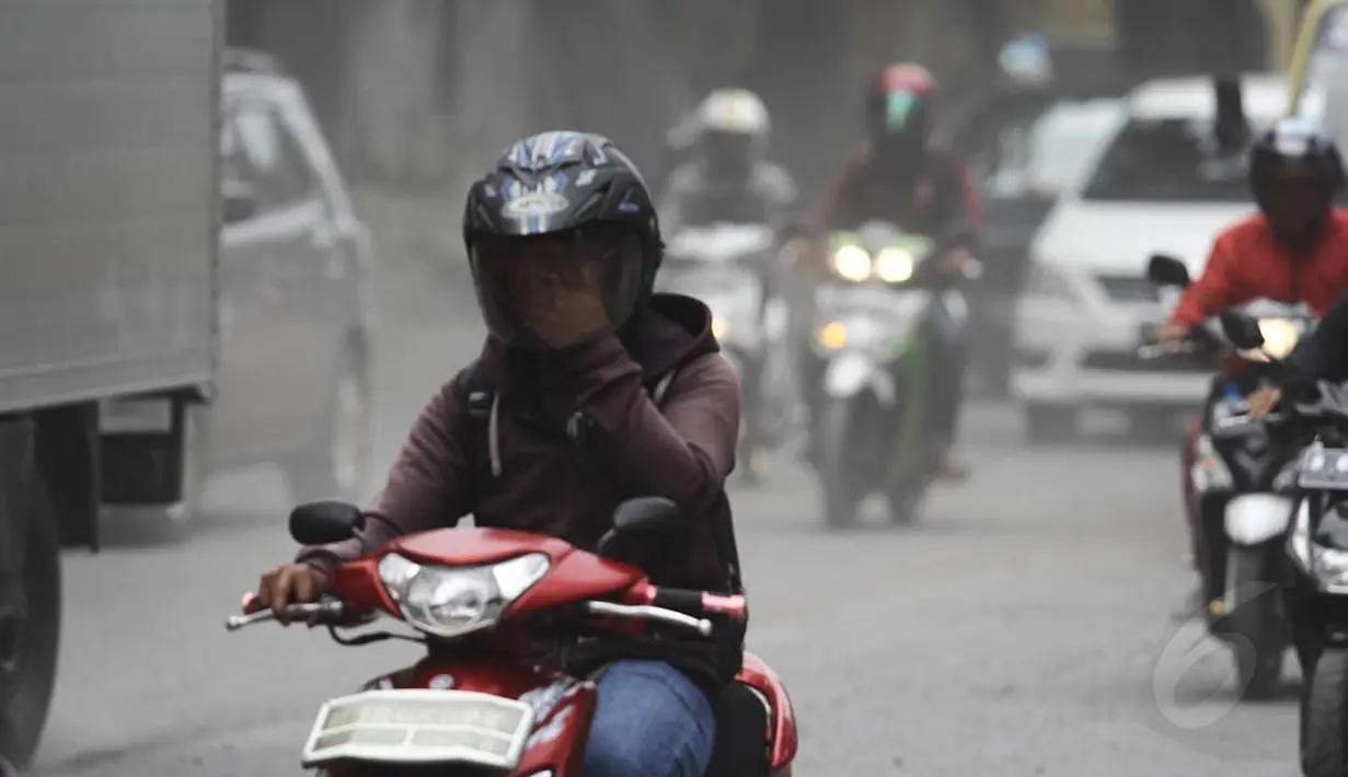 Pengendara motor menggunakan masker untuk menghindari debu saat melintasi Jalan Kemukus, Tamansari, Jakarta, Senin (24/11/2014). (Liputan6.com/Faizal Fanani)