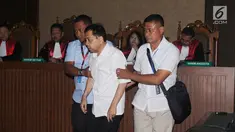 Tersangka korupsi e-KTP, Setya Novanto dipapah petugas saat memasuki ruang sidang Pengadilan Tipikor, Jakarta, Rabu (13/12). Sidang tersebut dipimpin oleh Ketua Majelis Hakim Yanto. (Liputan6.com/Helmi Fithriansyah)