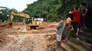 Sebuah buldoser membersihkan lumpur di daerah yang terkena banjir di distrik Juquehy di Sao Sebastiao, negara bagian Sao Paulo, Brasil (20/2/2023). Dampak bencana itu membuat perayaan karnaval di kota-kota tersebut terpaksa dibatalkan, dengan tim penyelamat berjuang untuk mencari korban hilang, korban luka dan dikhawatirkan tewas tertimbun puing-puing. (AFP/Nelson Almeida)