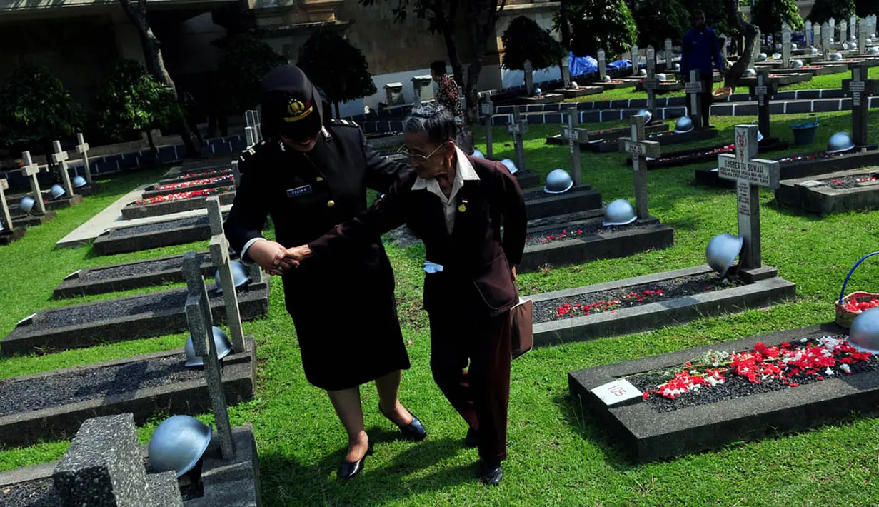 Istri almarhum Pembantu Letnan Satu Supadmo, Kasiyah (kiri) saat berjalan menuju makam suaminya di TMP Kalibata, Jakarta, Senin (10/11/2014). (Liputan6.com/Johan Tallo) 