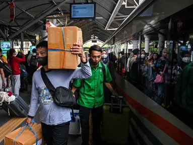 Calon penumpang Kereta Api Jarak Jauh (KAJJ) bersiap menaiki rangkaian kereta di stasiun Gubeng, Surabaya, 28 Maret 2025. (JUNI KRISWANTO/AFP)