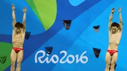 Atlet Tiongkok, Atlet dan Qin Kai saat mengikuti loncat indah sinkronisasi 3 m pria pada Olimpiade 2016 di Brasil, (10/8). Dalam cabang olahraga ini setiap negara harus memiliki 2 peserta.  (REUTERS/Antonio Bronic)