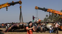 Seorang wanita berselfie saat proses evakuasi ikan paus paus yang terdampar di pantai sepanjang Laut Arab di Mumbai , India, (29/1). Diperkirakan ukuran ikan paus tersebut 9 meter .(REUTERS / Danish Siddiqui)