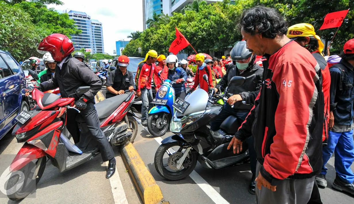 Pengendara motor harus menaiki jalur busway untuk bisa melintas di depan kantor Kemenkes, Jakarta Selatan, Rabu (4/5). Ribuan bidan desa menggelar aksi demo dan menutup akses jalur lambat di depan kantor Kemenkes. (Liputan6.com/Yoppy Renato)