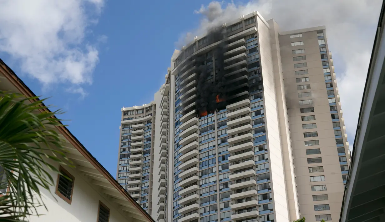 Kebakaran yang terjadi di apartemen Marco Polo, Honolulu (14/7). Hingga saat ini tim pemadam kebakaran masih terus berusaha menjinakkan api di apartemen tersebut. (AP Photo / Marco Garcia)