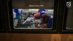 Penumpang bermain ponsel di dalam kereta di Stasiun Gambir, Jakarta, Minggu (26/5/2019). PT KAI bagian daerah operasional (Daop) 1 Jakarta akan menyediakan 957.282 tempat duduk (seat) kereta jarak jauh dan menengah sebagai upaya memenuhi kebutuhan angkutan lebaran 2019.  (Liputan6.com/Faizal Fanani)