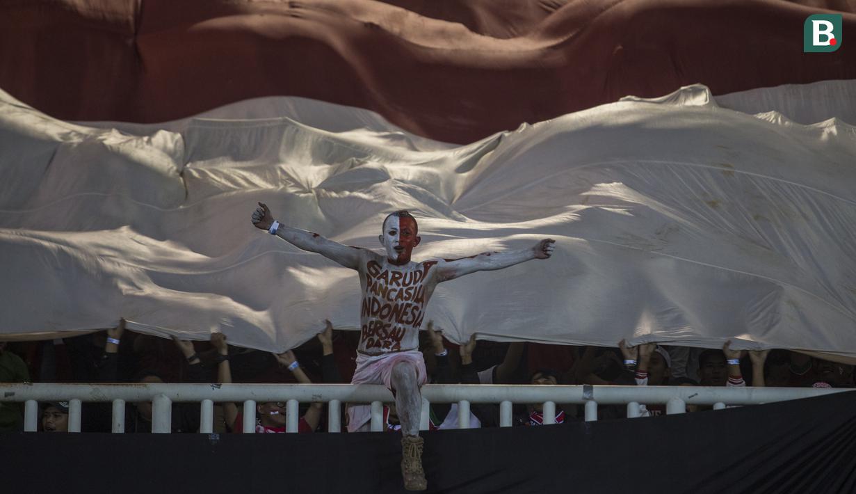 Suporter membentangkan bendera merah putih raksasa saat melawan China pada laga PSSI 88th U-19 di Stadion Pakansari, Jawa Barat, Selasa (25/9/2018). Indonesia kalah 0-3 dari China. (Bola.com/Vitalis Yogi Trisna)