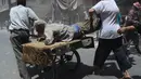 Ledakan bom mobil tersebut melukai orang yang sedang beraktivitas di   pusat kota Douma. Tampak seorang pria yang terluka dibawa dengan gerobak (REUTERS/Yousef Albostany)