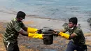 Tentara Sri Lanka bahu membahu membersihkan tumpahan minyak di sebuah pantai di Uswetakeiyawa, Kolombo, Senin (10/9). Meski kebocoran telah berhenti, butuh dua atau tiga hari untuk menyelesaikan pembersihan. (AP Photo/Eranga Jayawardena)