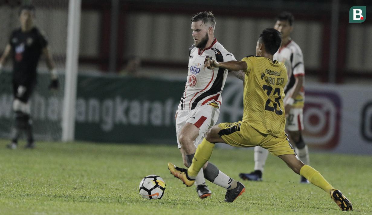 Gelandang Mitra Kukar, Danny Guthrie, berusaha melewati gelandang Bhayangkara FC, Wahyu Suboseto, pada laga Liga 1 di Stadion PTIK, Jakarta, Kamis (17/5/2018). Bhayangkara FC menang 1-0 atas Mitra Kukar. (Bola.com/M Iqbal Ichsan)