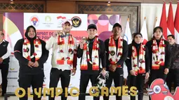 Dua atlet Indonesia peraih medali emas di Olimpiade 2024 Paris: Rizki Juniansyah dan Veddriq Leonardo (tengah) bersama rombongan terakhir atlet Indonesia yang berjuang di Olimpiade 2024 usai&nbsp;tiba di Bandara Internasional Soekarno-Hatta, Tangerang, Selasa (13/8/2024). (Abdul Aziz/Bola.com).