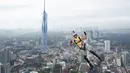 Seorang pelompat BASE terjun dari Menara Kuala Lumpur selama KL Tower International Jump Malaysia di Kuala Lumpur, Jumat (3/2/2023). Satu persatu peserta pemberani, ada juga yang sekaligus berdua, meloncat sambil membawa parasut masing-masing. (AP Photo/Vincent Thian)