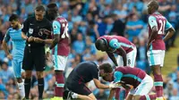 Bek West Ham United, Winston Reid, mendapat perawatan dari tim medis setelah disikut penyerang Manchester City, Sergio Aguero. (AFP/Jon Super)