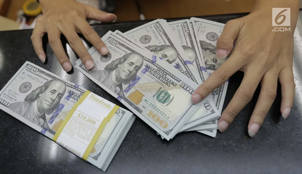 Teller menghitung mata uang dolar di penukaran uang di Jakarta, Jumat (20/4). Nilai tukar rupiah terhadap dolar Amerika Serikat (AS) mengalami pelemahan. (Liputan6.com/Angga Yuniar)