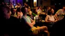 Orang-orang menghadiri pertunjukan stand-up comedy Serhiy Lipko di Kyiv, Ukraina, 11 Juni 2022. Perang Ukraina tidak terlalu lucu, tetapi orang-orang di sana belajar menertawakan kengerian itu semua untuk tetap waras dalam konflik yang telah menewaskan puluhan ribu orang tersebut. (AP Photo/Natacha Pisarenko)