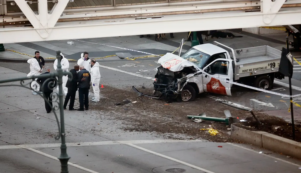 Petugas keamanan berdiri dekat sebuah truk dari Home Depot yang menabrak pejalan kaki dan pesepeda di dekat World Trade Center (WTC), New York, Selasa (31/10). Aksi itu menewaskan delapan orang dan melukai belasan lainnya. (AP/Bebeto Matthews)