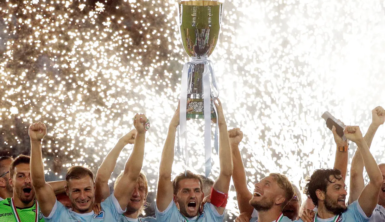 Para pemain Lazio mengangkat trofi usai mengalahkan Juventus pada pertandingan final Piala Super Italia di stadion Olimpiade Roma, Italia (13/8). Lazio menang atas Juventus dengan skor 3-2. (AP Photo / Gregorio Borgia)