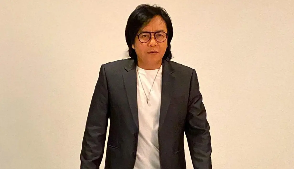 Pelantun lagu Hampa ini juga pernah menjalani pemotretan saat memakai setelan jas. Namun, alih-alih menggunakan kemeja, Ari Lasso justru memilih memakai kaus polos berwarna putih. (Liputan6.com/IG/@ari_lasso)