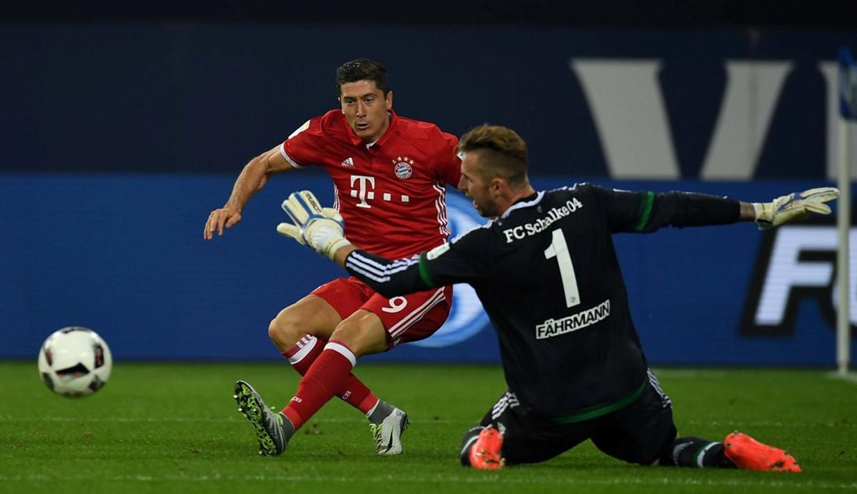 Striker Bayern Munchen, Robert Lewandowski, berusaha menaklukkan kiper Schalke 04, Ralf Faehrmann, dalam lanjutan Bundesliga di Veltins Arena, Gelsenkirchen, Sabtu (10/9/2016) dini hari WIB. (AFP/Patrik Stollarz)