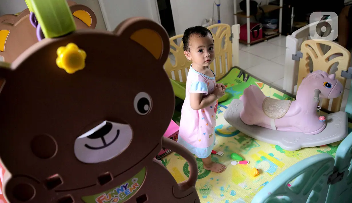Seorang anak bermain di dalam rumah di Kawasan Jakarta, Minggu (29/3/2020). Aktivitas bermain di dalam rumah saat ini menjadi alternatif warga dalam mengurangi interaksi sosial sebagai upaya pencegahan penyebaran virus corona atau COVID-19. (Liputan6.com/Faizal Fanani)