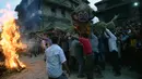 Para lelaki Nepal membawa patung jerami iblis Ghantakarna untuk dibakar dalam festival Ghantakarna di kota kuno Bhaktapur, Nepal (30/7/2019). Festival Hindu ini juga dikenal dengan nama Gathemangal. (AFP Photo/Prakash Mathema)