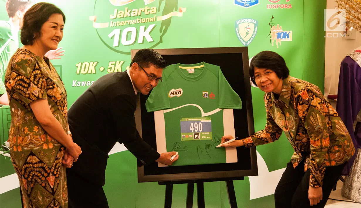 Business Executive Manager Beverages PT Nestlé Indonesia, Prawitya Soemadijo (kanan) bersama Kepala Dinas Olahraga dan Pemuda DKI Jakarta Ratiyono membubuhkan tanda tangan di kaos lomba lari Milo 10K di Jakarta (15/6). (Liputan6.com/Gempur M Surya)