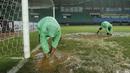 Para petugas berusaha menguras air yang menggenangi lapangan di Stadion Patriot, Bekasi, Senin (13/11/2017). Drainase yang buruk menyebabkan lapangan terendam air. (Bola.com/M Iqbal Ichsan)