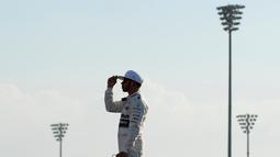 Pebalap Mercedes, Lewis Hamilton bersiap sebelum lomba F1 GP Abu Dhabi yang berlangsung di Sirkuit Yas Marina, Abu Dhabi, UEA, Minggu (29/11/2015). (AFP/Tom Gandolfini)