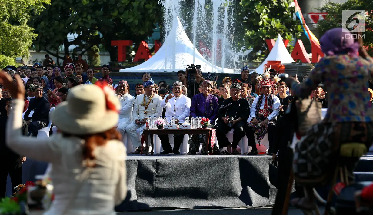Presiden Joko Widodo (Jokowi) bersama Gubernur Jawa Barat, Ahmad Heryawan dan Wali Kota Bandung Ridwan Kamil menyaksikan rombongan Karnaval Kemerdekaan Pesona Parahyangan yang melintas di Taman Vanda, Bandung,  Sabtu (26/8). (Liputan6.com/Johan Tallo)
