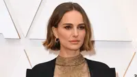 Natalie Portman mengenakan jubah di atas gaun hitam saat menghadiri ajang Academy Awards ke-92 atau Oscar 2020 di Dolby Theatre, Los Angeles, Minggu (9/2/2020). Portman mengenakan jubah Dior yang disulam dengan nama-nama sutradara perempuan yang tidak mendapatkan Oscar tahun ini. (Robyn Beck/AFP)