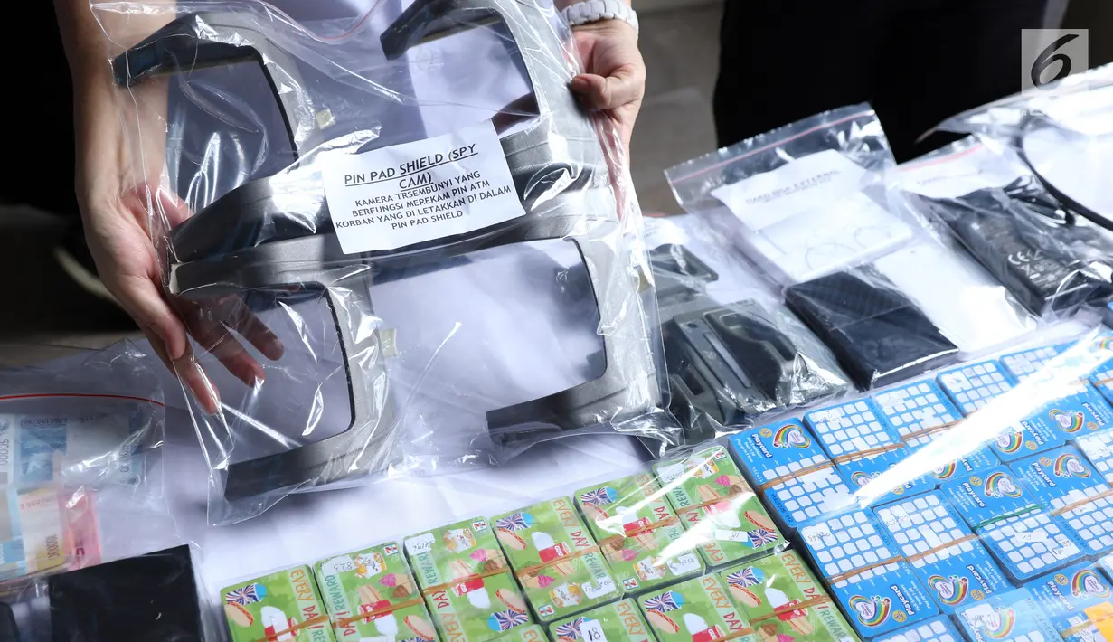 Petugas menunjukkan barang bukti pembobol uang dengan teknik skimming diperlihatkan petugas Resmob Polda Metro Jaya saat rilis di Jakarta, Sabtu (17/3). Sindikat ini membobol 64 bank pada sejumlah negara. (Liputan6.com/Helmi Fithriansyah)