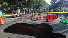 Pengendara melintas di sisi ruas jalan yang ditutup sebagian akibat amblas di Jalan Raya Lenteng Agung, Jakarta Selatan, Jumat (29/5/2026). (merdeka.com/Arie Basuki)