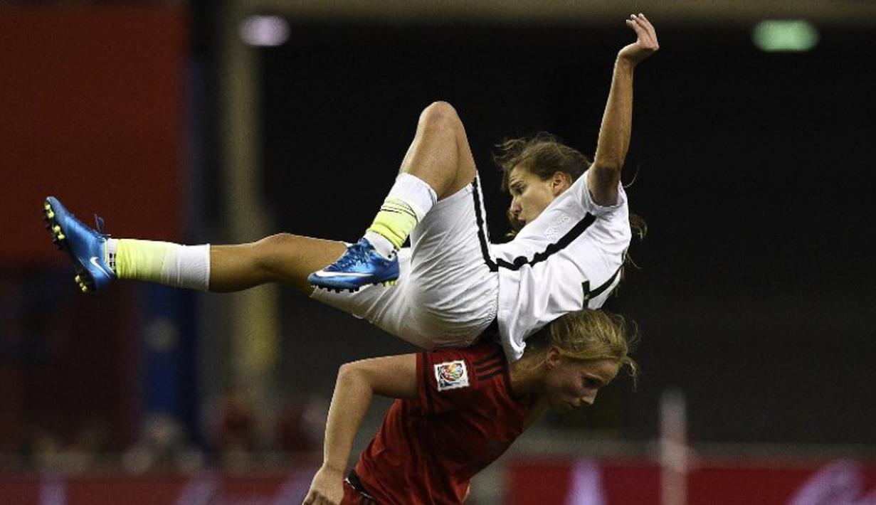 Pemain AS, Tobin Heath (Atas) berebut bola dengan pemain Jerman Tabea Kemme dalam semifinal Piala Dunia Wanita 2015 di Stadion Olimpiade di Montreal, Kanada. (30/6/2015). (AFP PHOTO/Franck Fife)