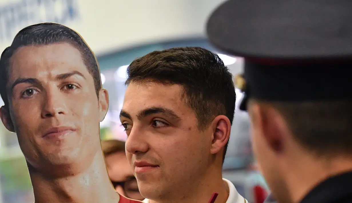 Suporter Portugal membawa patung Cristiano Ronaldo saat tiba di Bandara Zhukovsky, Moskow, Sabtu (9/6/2018). CR 7 akan berjuang bersama Portugal pada ajang Piala Dunia 2018 Rusia. (AFP/Yuri Kadobnov)